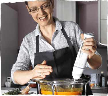 Gute Ernährung als Teil der integrativen Onkologie: Frau püriert Suppe in einem Topf